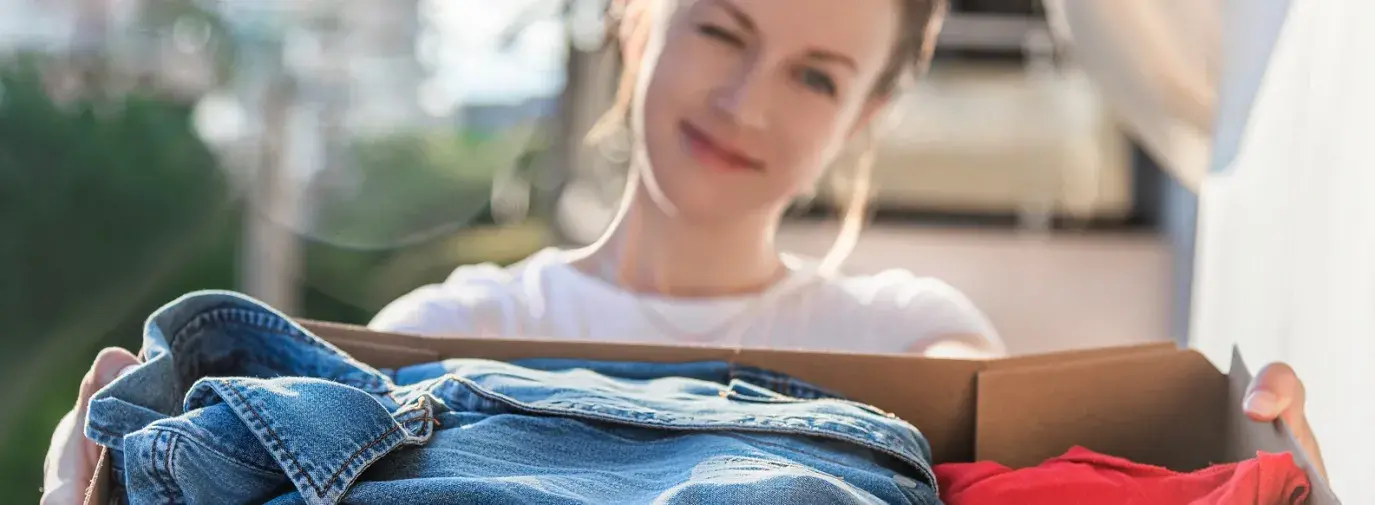 woman holding box of clothes