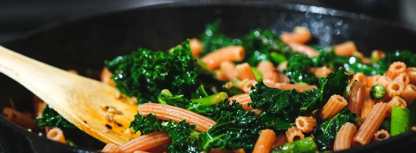 pasta and kale on a cast iron