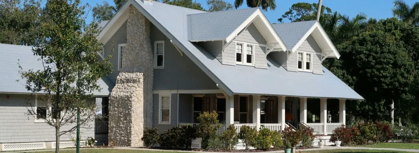 a gray suburban style house with a green yard.