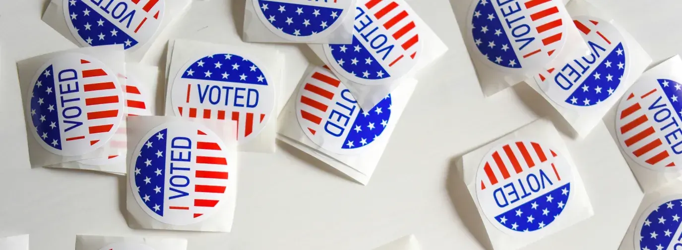 I voted stickers scattered across a white table.