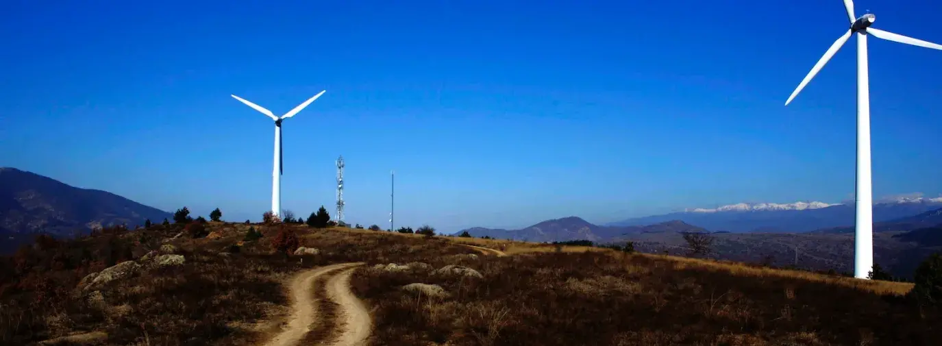 Image: wind turbines against a clear blue sky. Title: The Power of Divestment