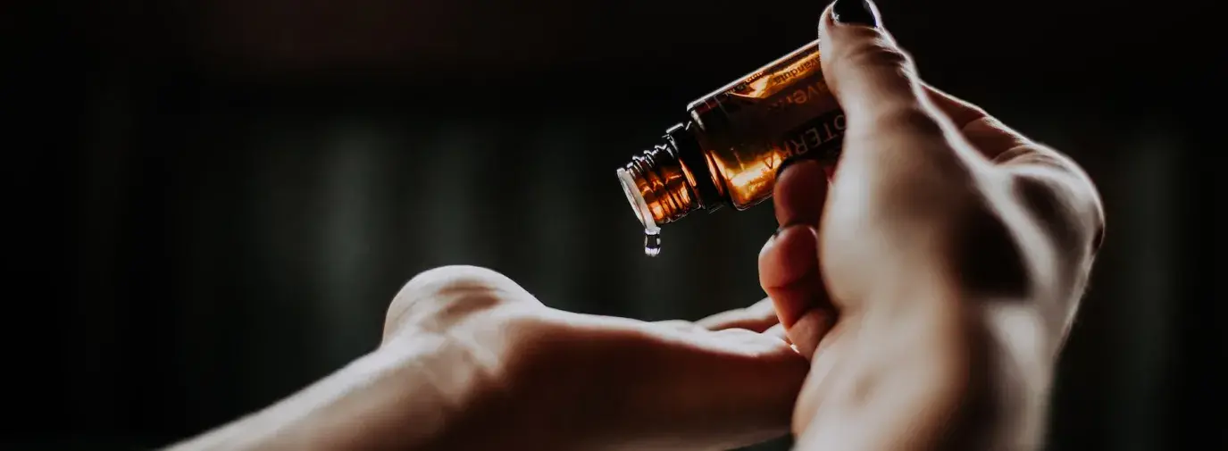 person holding glass bottle