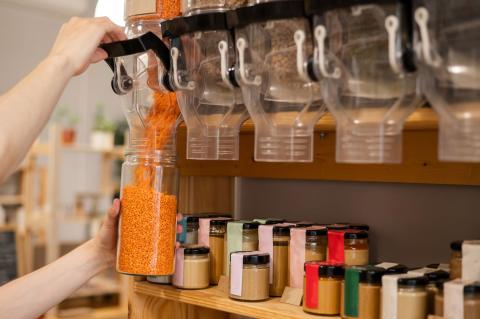 refilling a jar in the bulk aisle of a store