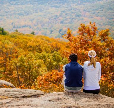 Two people look over a scenic fall landscape