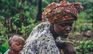 Image: baby on mother's back. Topic: What Is Fair Trade and Fair Labor?