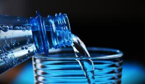 Image: water being poured from a bottle into a glass. Title: Why Bottled Water Isn’t Better