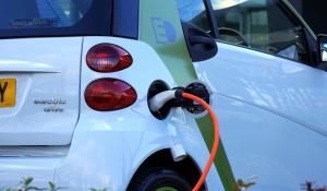 Image: hybrid vehicle plugged in. Topic: The Money-Saving Perks of a Hybrid Car