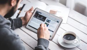 Image: man on tablet with a cup of coffee. Title: FAQs about Shareholder Activism