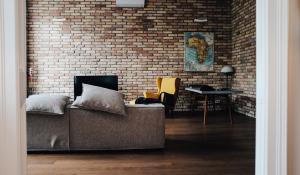 living room with brick walls, a grey couch and a cartographer's map of Africa on the wall