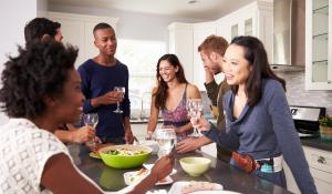 Image: gathering of people with around around kitchen island. Title: Throwing a Fair Trade Party