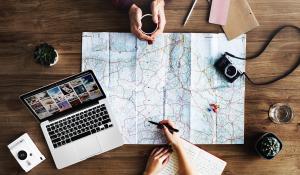 Image: map, laptop, camera, and notepad on table. Title: Eco-Travel Checklist