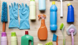 Image: an array of cleaning products on a table. Topic: 13 Toxic Chemicals Lurking in Your Home