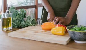 Image: woman chopping peppers. Topic: 5 Foods to Boost Your Immune System