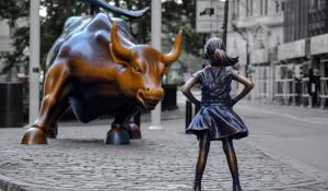 photo of the wall street bull facing a brass statue of a young girl standing proudly with her hands on her hips.