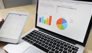 Image: financial charts on laptop. Title: Find Fossil-Free Financial Products & Services