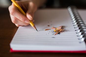 Person writing on a notebook